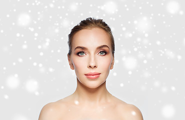 Image showing beautiful young woman face over snow