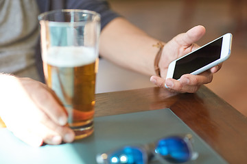 Image showing close up of man with smartphone and beer at pub