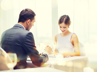 Image showing smiling couple eating dessert at restaurant