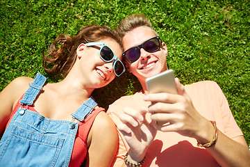 Image showing happy teenage couple smartphone lying on grass