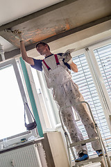 Image showing Plasterer renovating indoor walls and ceilings. Finishing works.