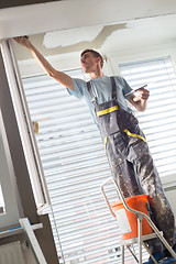 Image showing Plasterer renovating indoor walls and ceilings. Finishing works.