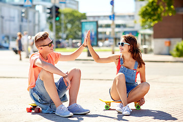 Image showing teenage couple with skateboards on city street