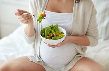 Image showing close up of pregnant woman eating salad at home