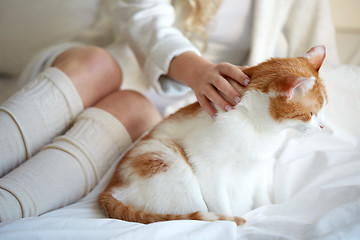 Image showing happy young woman with cat in bed at home