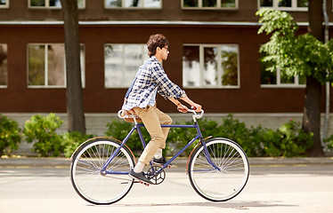 Image showing young hipster man with bag riding fixed gear bike