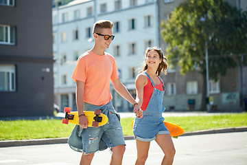 Image showing teenage couple with skateboards on city street