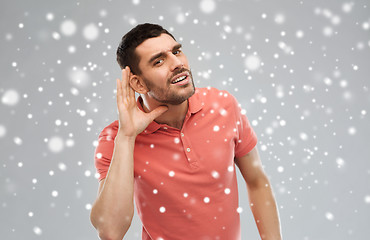 Image showing man having hearing problem listening to something