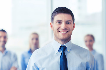 Image showing smiling businessman with colleagues in office