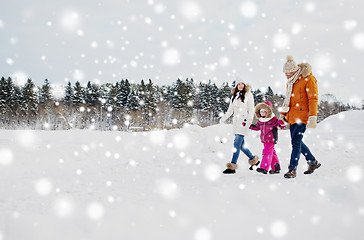 Image showing happy family in winter clothes walking outdoors