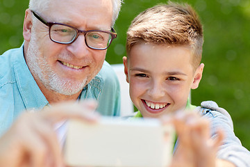 Image showing old man and boy taking selfie by smartphone