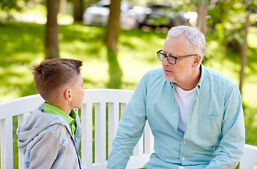 Image showing grandfather and grandson talking at summer park