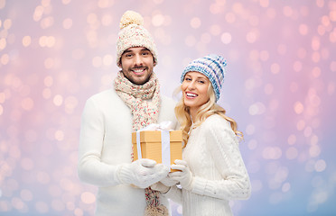 Image showing smiling couple in winter clothes with gift box