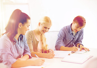 Image showing smiling students with notebooks at school