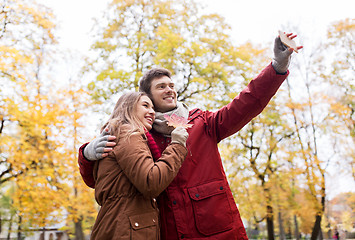 Image showing couple taking selfie by smartphone in autumn park