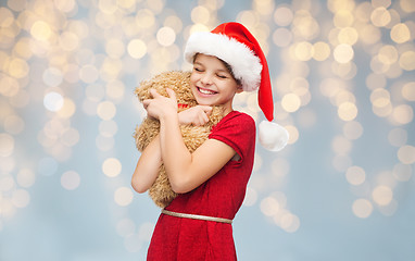 Image showing smiling girl in santa helper hat with teddy bear