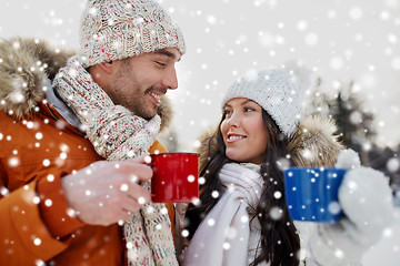 Image showing happy couple with tea cups over winter landscape