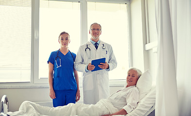 Image showing doctor and nurse visiting senior woman at hospital