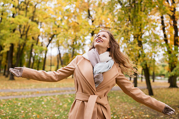 Image showing beautiful happy young woman walking in autumn park