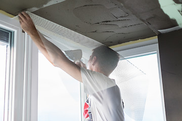 Image showing Plasterer renovating indoor walls and ceilings. Finishing works.