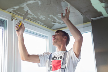 Image showing Plasterer renovating indoor walls and ceilings. Finishing works.