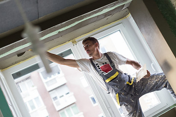 Image showing Plasterer renovating indoor walls and ceilings. Finishing works.