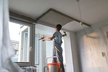 Image showing Plasterer renovating indoor walls and ceilings. Finishing works.