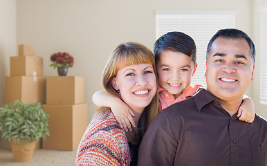 Image showing Mixed Race Family with Baby in Room with Packed Moving Boxes