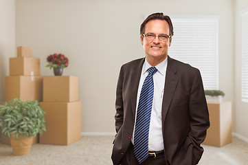 Image showing Businessman in Empty Room with Packed Boxes and Plants