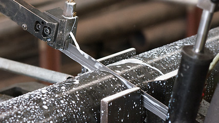 Image showing Bandsaw cutting a steel pipe