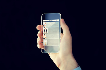 Image showing close up of male hand with transparent smartphone