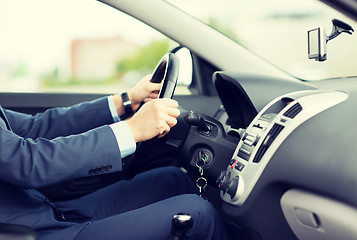 Image showing close up of young man in suit driving car