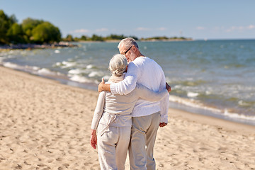 Image showing happy senior couple hugging on summer beach