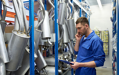 Image showing auto mechanic calling on phone at car shop