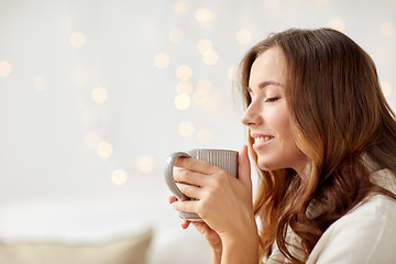 Image showing happy woman with cup of tea or coffee at home