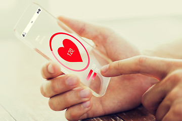 Image showing close up of hand with heart rate on smartphone