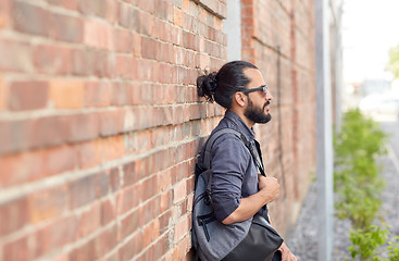 Image showing man with backpack standing at city street wall