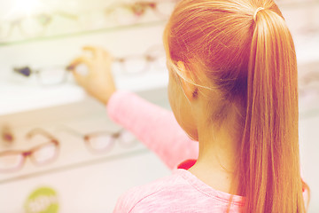 Image showing close up of girl choosing glasses at optics store