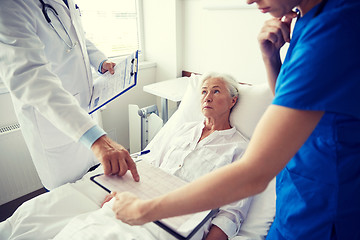 Image showing doctor and nurse visiting senior woman at hospital