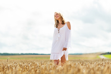 Image showing smiling young woman in white dress on cereal field