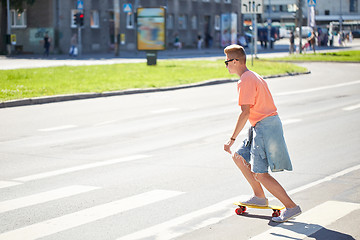 Image showing teenage boy on skateboard crossing city crosswalk