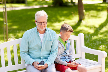 Image showing old man and boy with smartphones at summer park