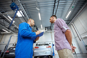 Image showing auto mechanic with clipboard and man at car shop