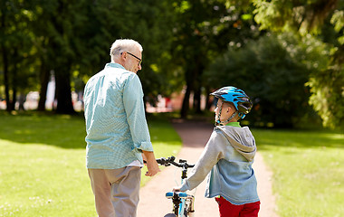 Image showing grandfather and boy with bicycle at summer park