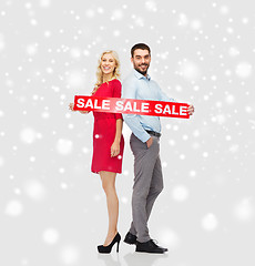 Image showing happy couple with red sale sign over snow