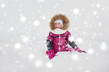 Image showing happy little kid or girl in winter clothes on snow