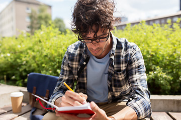 Image showing man with notebook or diary writing on city street