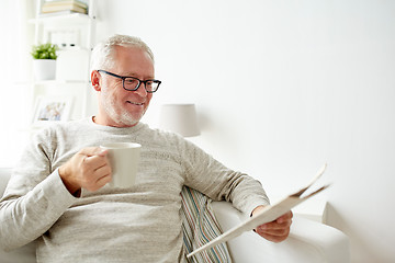 Image showing senior man in glasses reading newspaper at home