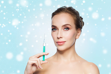 Image showing beautiful woman holding syringe with injection