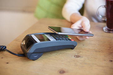 Image showing Woman uses smart phone to pay